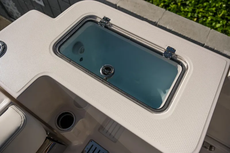 Slide: The Image of 2025 Robalo R300 Center Console livewell with textured surface and secure latch. - 24