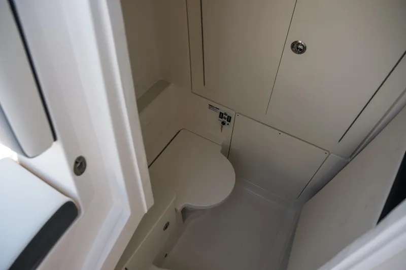 Slide: The Image of 2025 Robalo R300 Center Console boat interior bathroom with compact design and modern fixtures. - 25