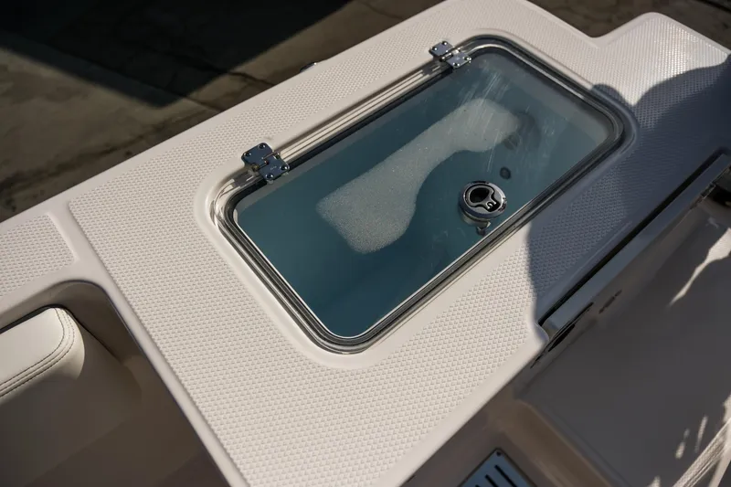 Slide: The Image of 2025 Robalo R300 Center Console livewell with textured surface and secure latch. - 29