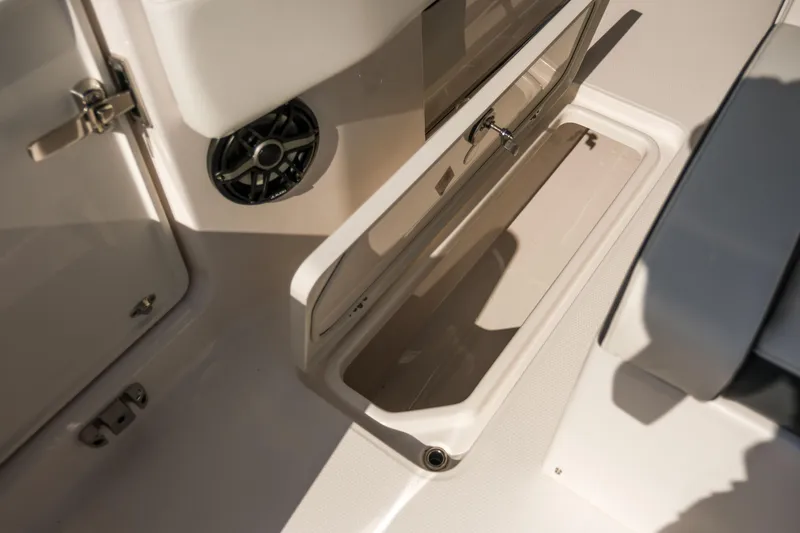 Slide: The Image of 2025 Robalo R300 Center Console boat storage compartment and speaker detail. - 31