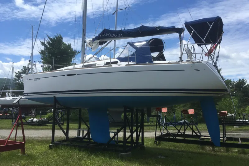 Slide: The Image of 2004 Dufour 34 Performance sailboat on stands, under a blue sky. - 10