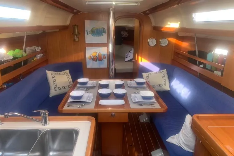 Slide: The Image of Interior of 2004 Dufour 34 Performance yacht with dining area and blue seating. - 16