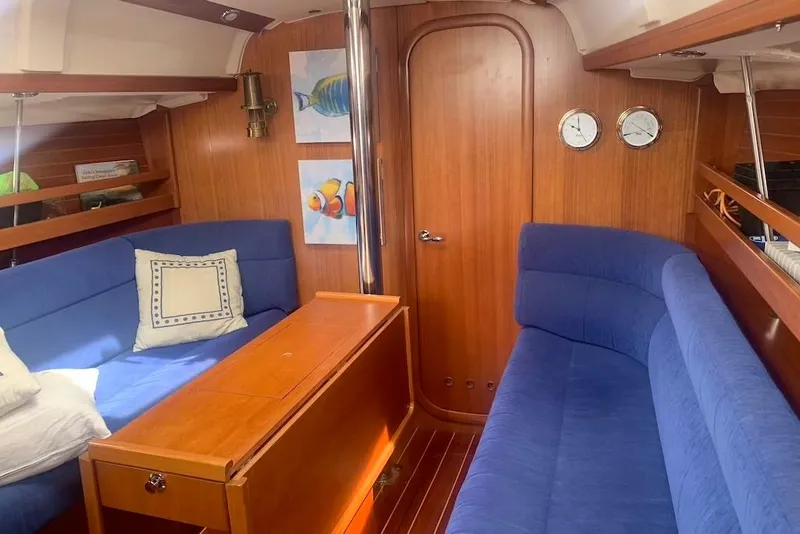 Slide: The Image of Interior of 2004 Dufour 34 Performance yacht with blue seating and wooden finishes. - 18