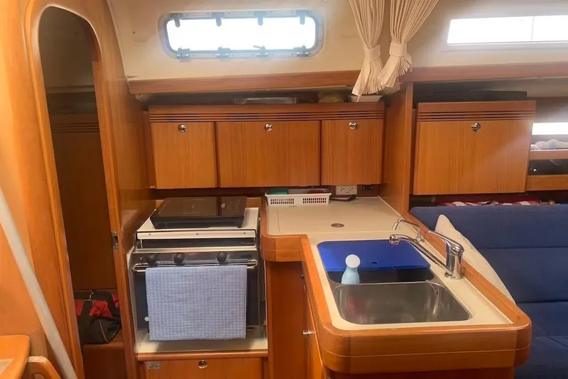 Slide: The Image of Interior of 2004 Dufour 34 Performance yacht, featuring a compact kitchen area. - 19