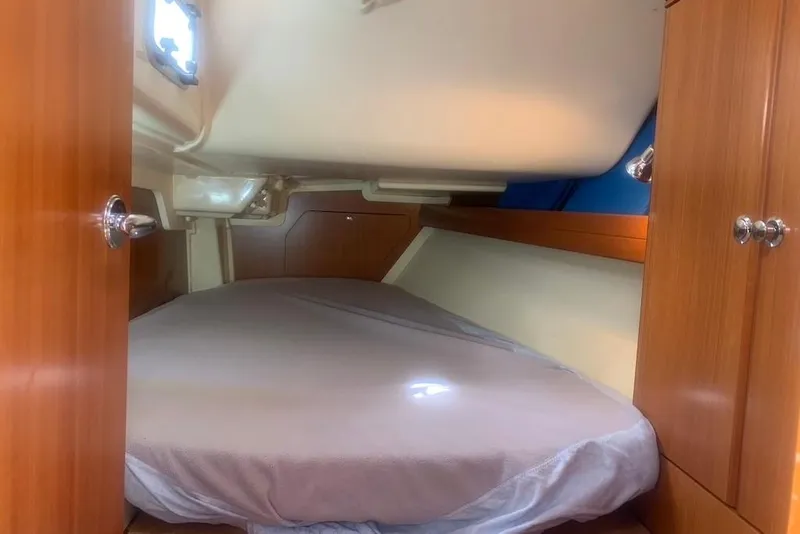 Slide: The Image of Cozy cabin interior of 2004 Dufour 34 Performance sailboat with wooden cabinetry and bed. - 28