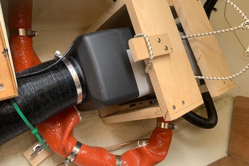 Slide: The Image of Engine compartment of a 2004 Dufour 34 Performance sailboat, featuring hoses and wooden supports. - 36
