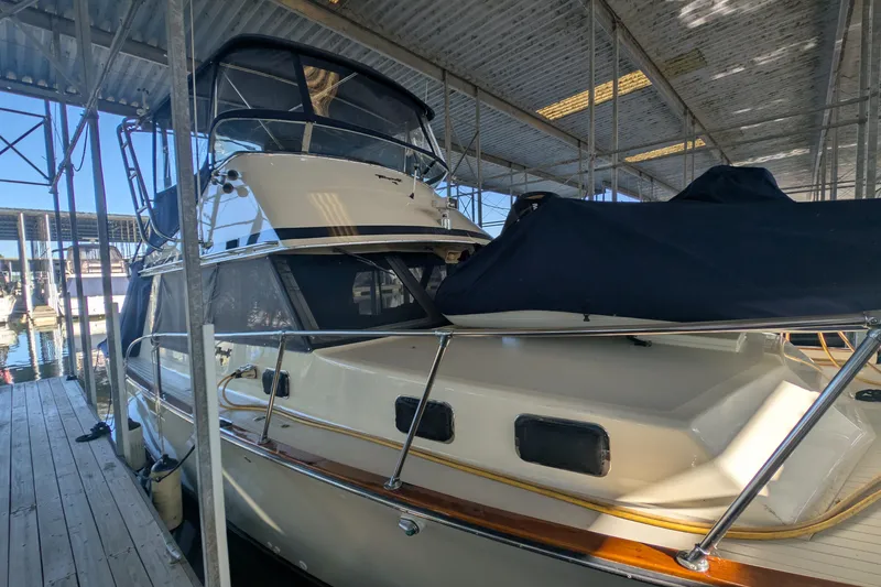 Slide: The Image of 1975 Tollycraft 37 Sedan boat docked under a covered marina. - 11
