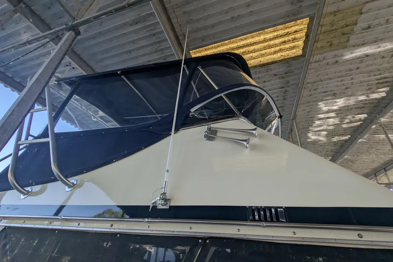 Slide: The Image of 1975 Tollycraft 37 Sedan under a covered dock, showcasing its sleek design and structure. - 13