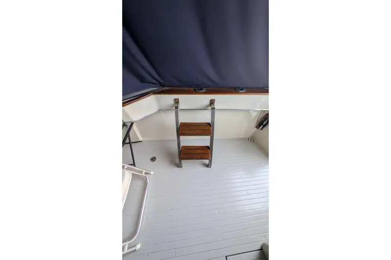 Slide: The Image of 1975 Tollycraft 37 Sedan interior with wooden steps and blue curtain. - 18