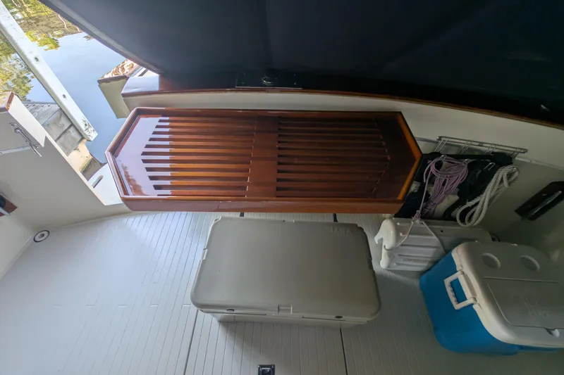 Slide: The Image of 1975 Tollycraft 37 Sedan interior with wooden table, storage, and coolers. - 20