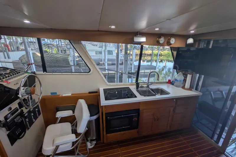Slide: The Image of Interior of a 1975 Tollycraft 37 Sedan yacht with helm, kitchen, and scenic window view. - 24