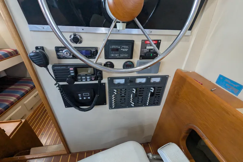 Slide: The Image of 1975 Tollycraft 37 Sedan helm with steering wheel, control panels, and communication equipment. - 29
