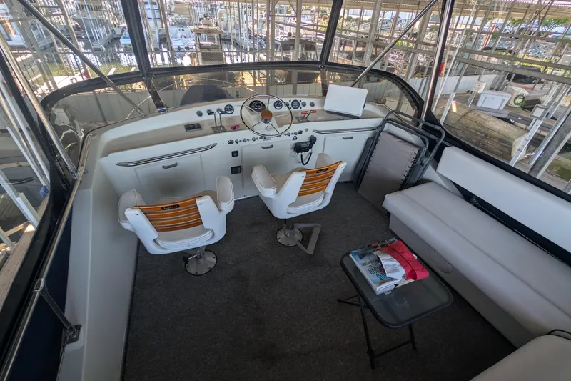 Slide: The Image of 1975 Tollycraft 37 Sedan boat interior with helm, seating, and marina view. - 32