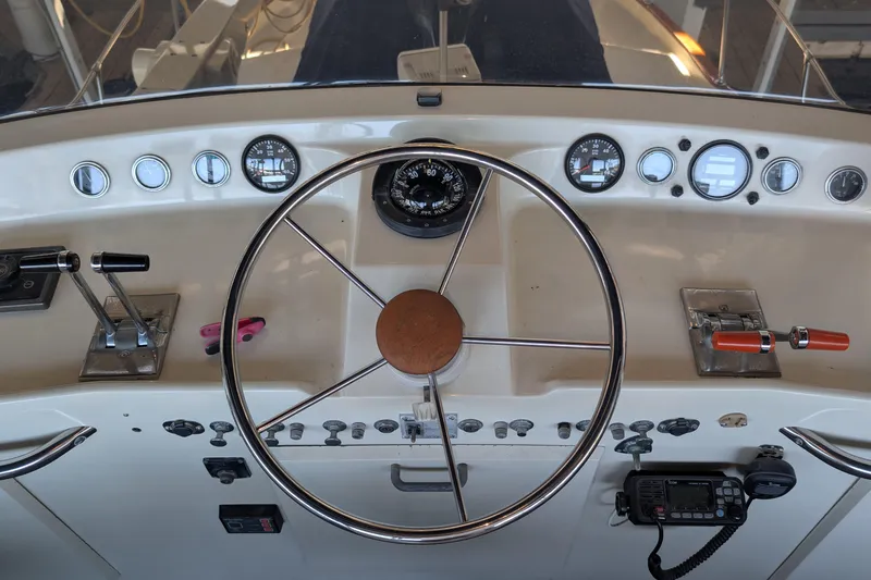 Slide: The Image of 1975 Tollycraft 37 Sedan helm with steering wheel, gauges, and controls. - 33