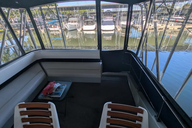 Slide: The Image of 1975 Tollycraft 37 Sedan interior with marina view, featuring seating and a small table. - 36