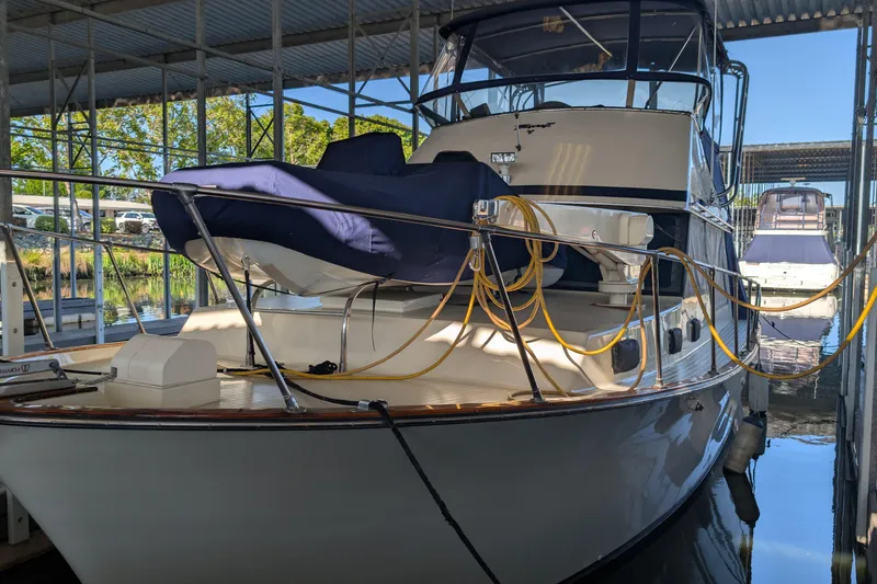 Slide: The Image of 1975 Tollycraft 37 Sedan yacht docked in a marina under a covered structure. - 4
