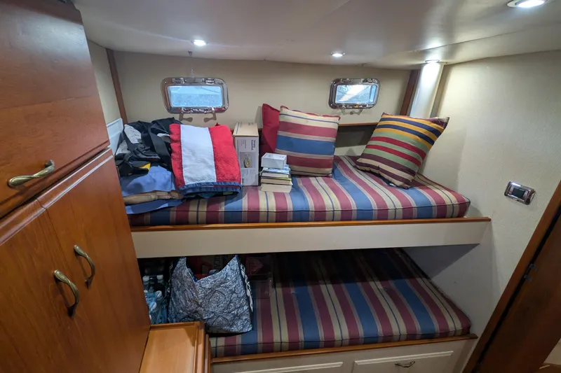 Slide: The Image of Cozy cabin interior of 1975 Tollycraft 37 Sedan with striped bedding and storage. - 40