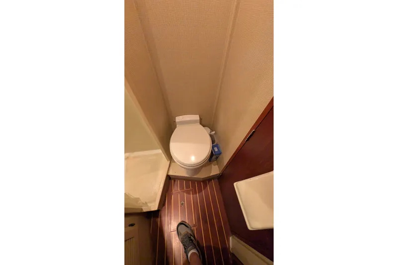 Slide: The Image of 1975 Tollycraft 37 Sedan bathroom with wooden flooring and compact toilet. - 48