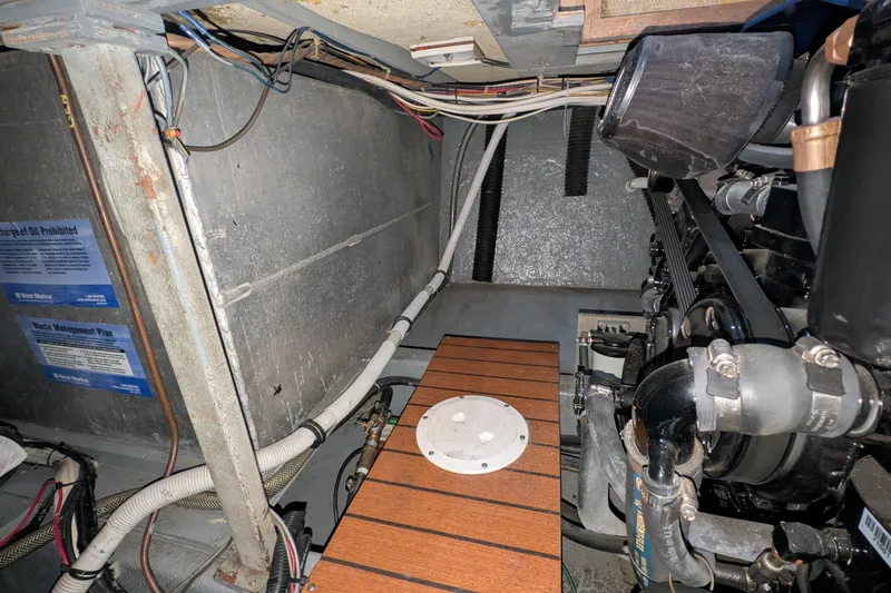 Slide: The Image of Engine room of a 1975 Tollycraft 37 Sedan with visible machinery and wiring. - 57