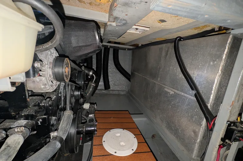 Slide: The Image of Engine compartment of a 1975 Tollycraft 37 Sedan boat, showcasing mechanical components and wiring. - 58