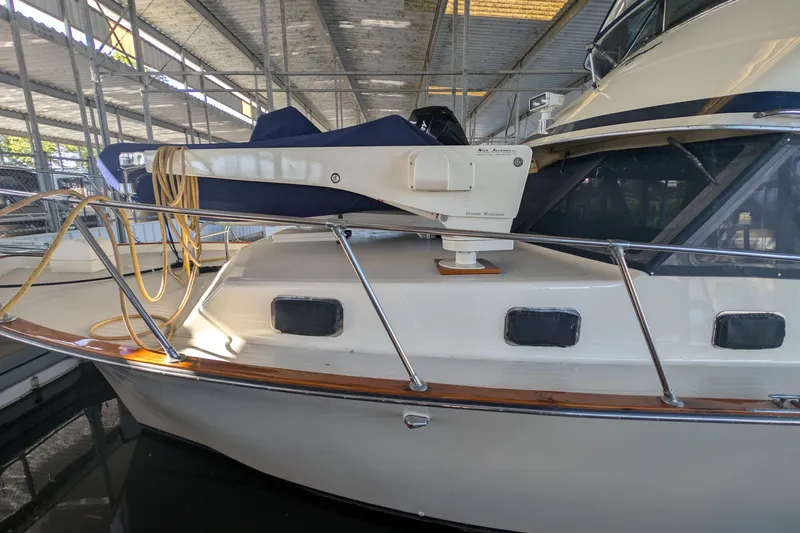 Slide: The Image of 1975 Tollycraft 37 Sedan boat docked in a covered marina, showcasing its classic design. - 6