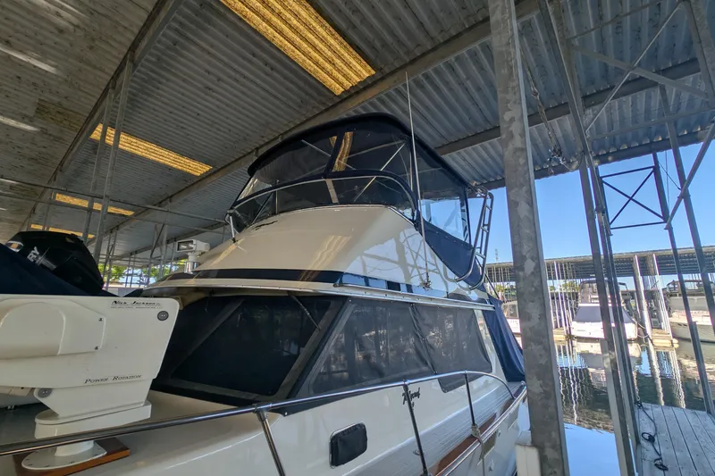 Slide: The Image of 1975 Tollycraft 37 Sedan yacht docked under a covered marina. - 7