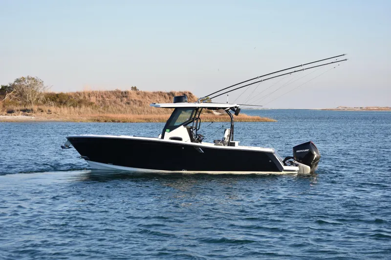 The Image of 2022 Blackfin 272 CC boat cruising on a calm lake with fishing rods. - 0