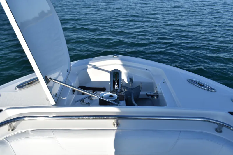 Slide: The Image of 2022 Blackfin 272 CC boat anchor compartment open on calm water. - 13
