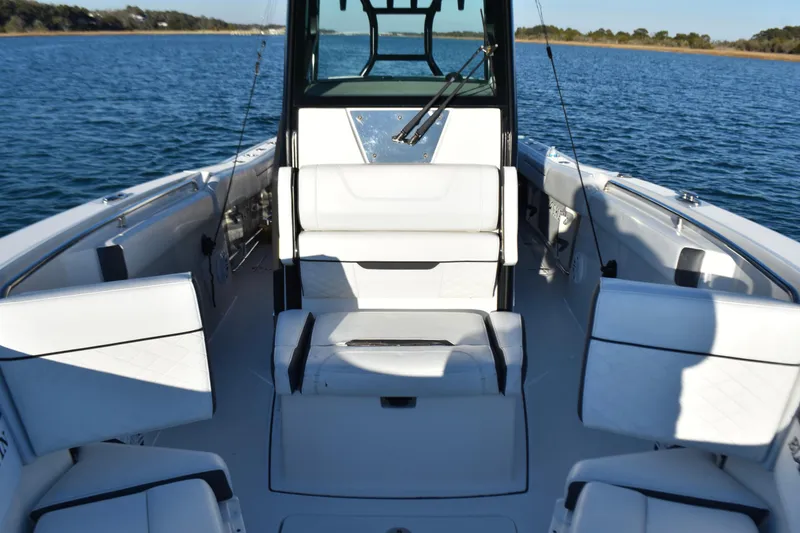 Slide: The Image of 2022 Blackfin 272 CC boat interior with white seating on calm water. - 14