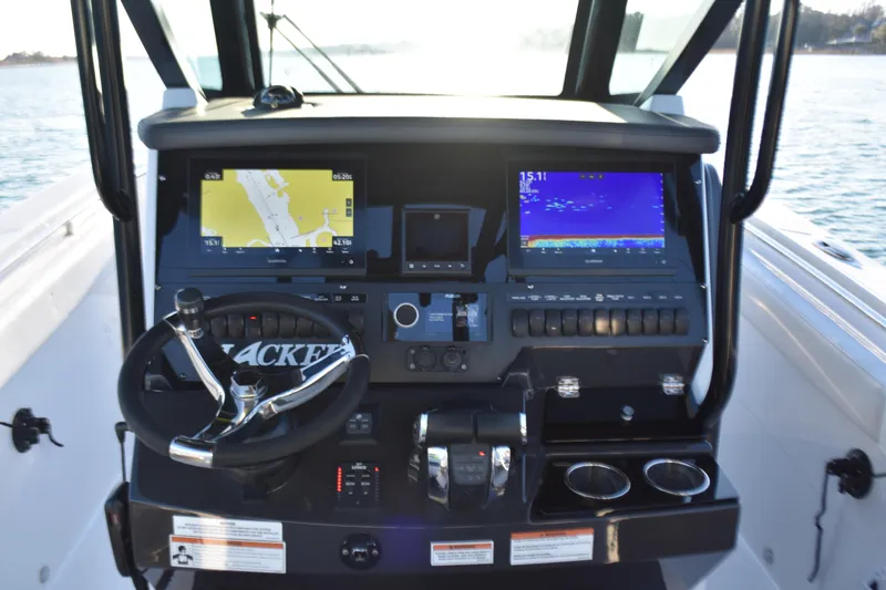 Slide: The Image of 2022 Blackfin 272 CC boat dashboard with navigation screens and steering wheel. - 17
