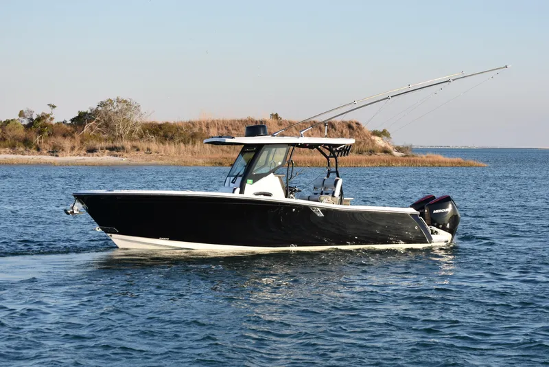 Slide: The Image of 2022 Blackfin 272 CC boat cruising on a serene waterway. - 2