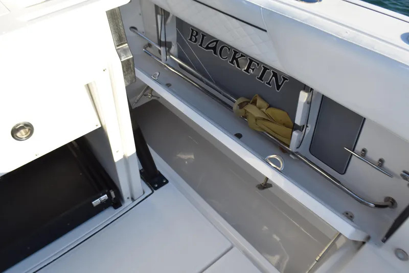 Slide: The Image of 2022 Blackfin 272 CC boat interior storage compartment with logo and equipment. - 25