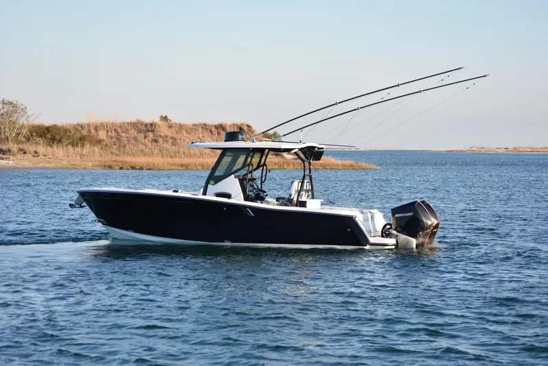 Slide: The Image of 2022 Blackfin 272 CC boat cruising on a calm lake with fishing rods. - 3