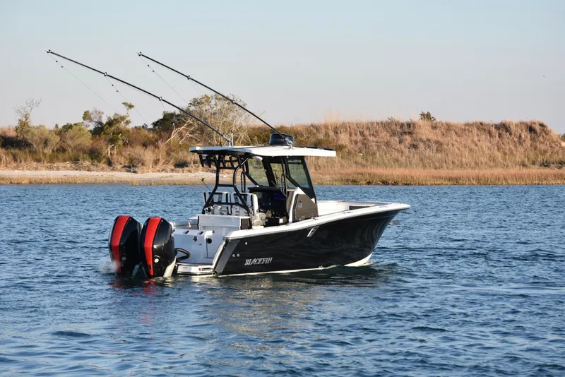 Slide: The Image of 2022 Blackfin 272 CC boat on calm water with fishing rods. - 6