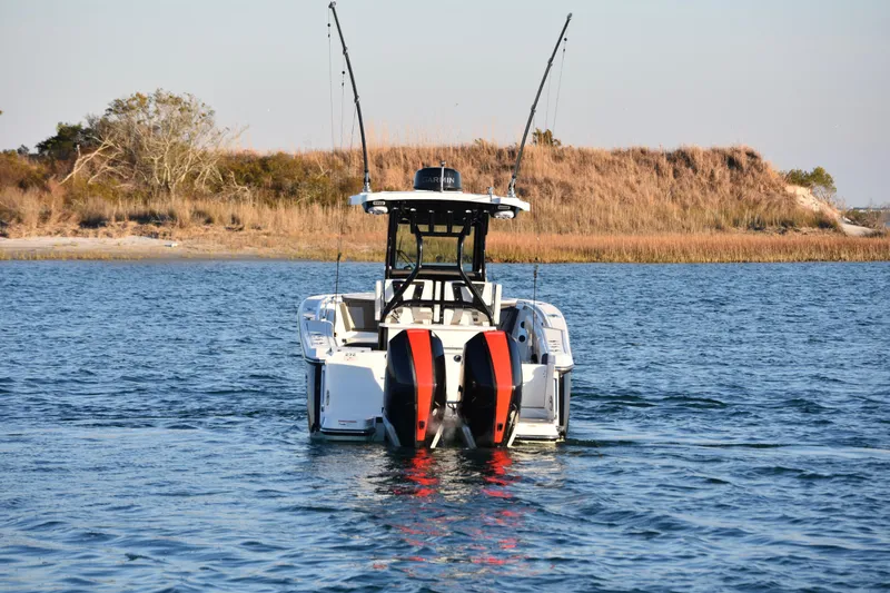 Slide: The Image of 2022 Blackfin 272 CC boat on water, dual engines, coastal background. - 7