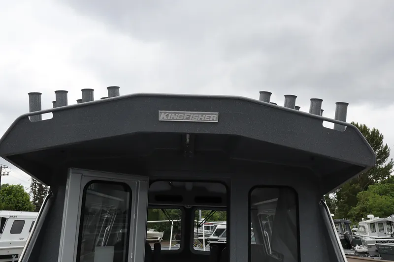 Slide: The Image of 2026 KingFisher 2825 Coastal Express boat with rod holders, under cloudy sky. - 20