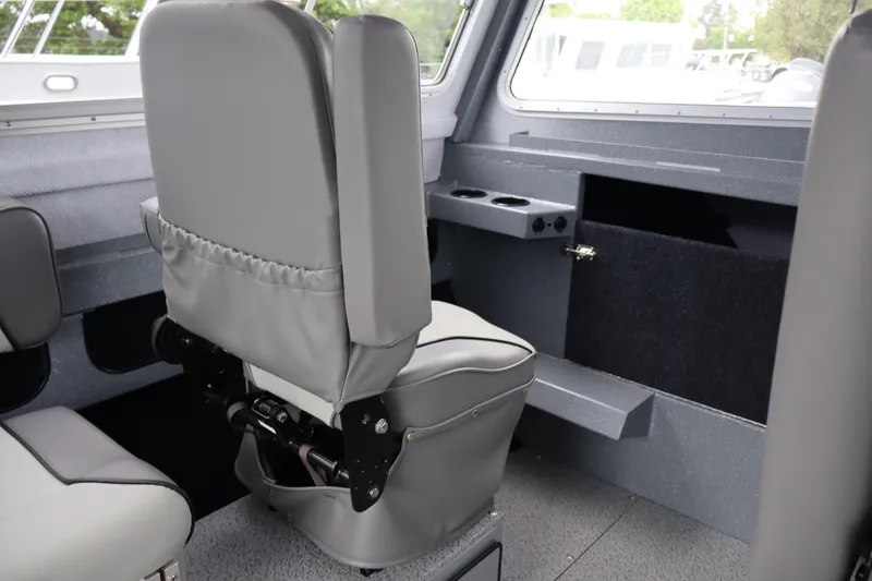 Slide: The Image of Interior of 2026 KingFisher 2825 Coastal Express boat, featuring gray seating and storage compartments. - 24