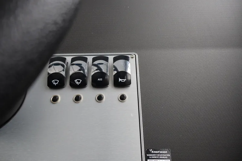 Slide: The Image of Control panel of 2026 KingFisher 2825 Coastal Express boat with labeled switches. - 29