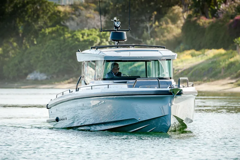 Slide: The Image of 2026 Axopar 37 XC Cross Cabin cruising on a serene waterway. - 3