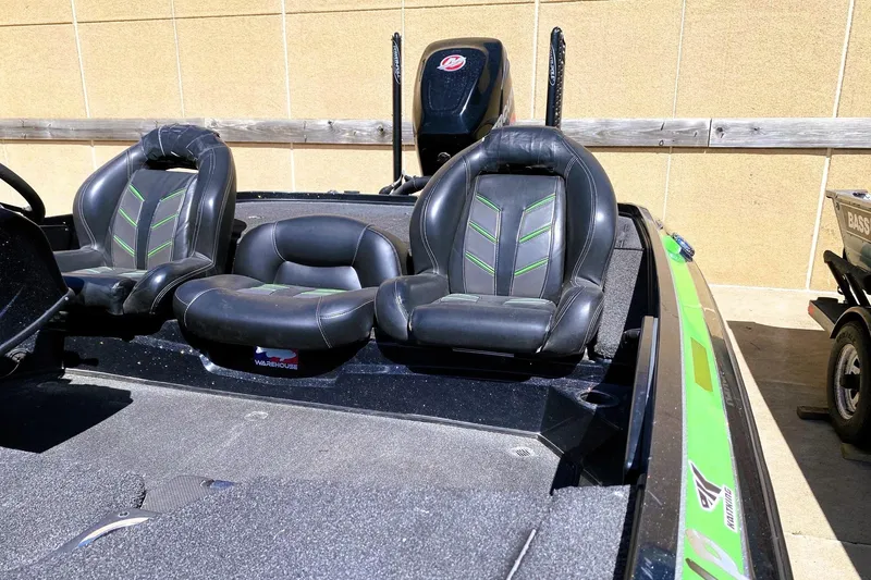 Slide: The Image of 2017 Nitro Z19 boat interior with black and green seats, parked outdoors. - 11