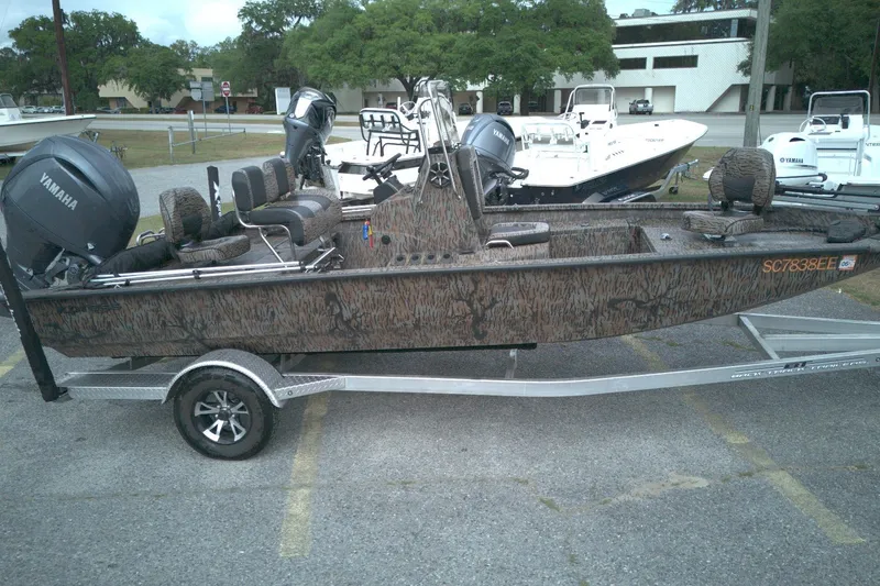 The Image of 2024 Xpress H20B Bay boat with Yamaha engine on trailer, parked outdoors. - 1
