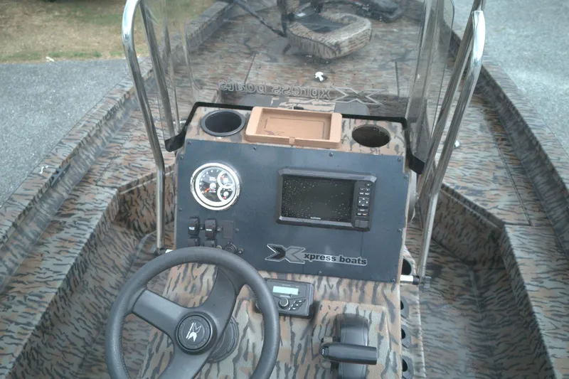 Slide: The Image of 2024 Xpress H20B Bay boat dashboard with steering wheel and navigation system. - 11