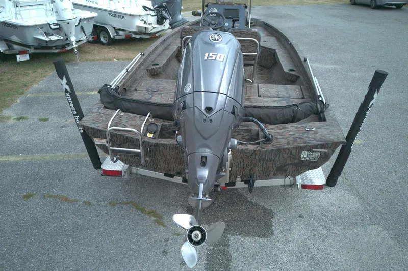 Slide: The Image of 2024 Xpress H20B Bay boat with Yamaha 150 engine, parked on a trailer. - 13