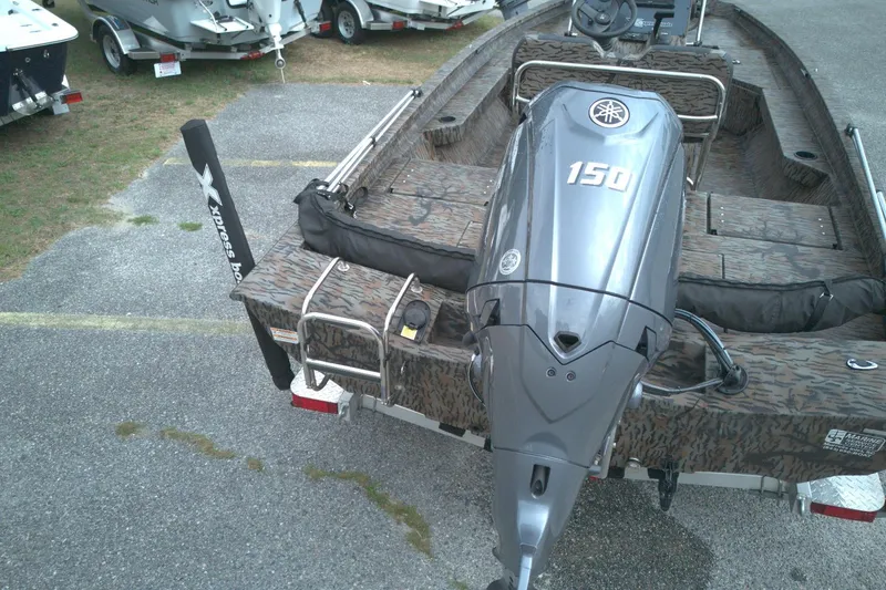 Slide: The Image of 2024 Xpress H20B Bay boat with Yamaha 150 engine, parked on a trailer. - 14