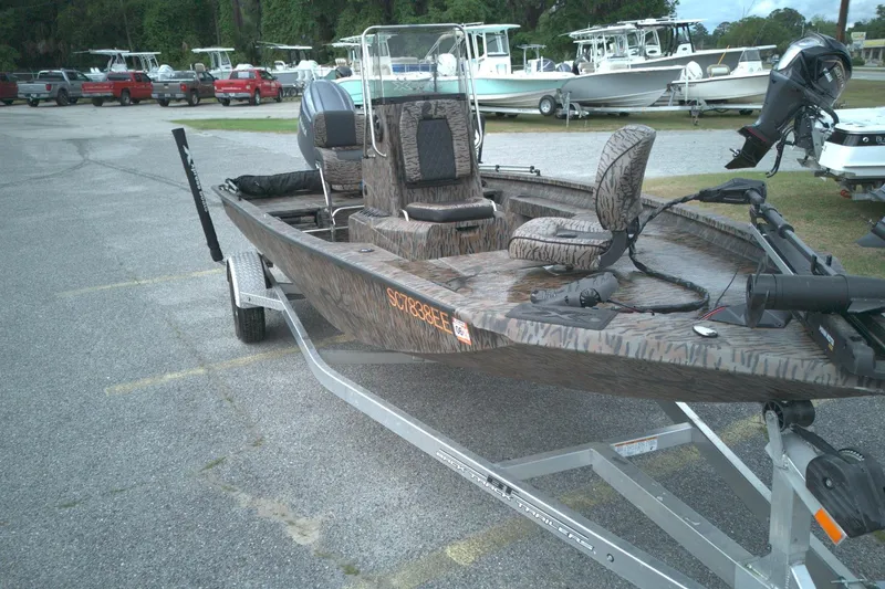 Slide: The Image of 2024 Xpress H20B Bay boat on trailer in parking lot, featuring camouflage design. - 15
