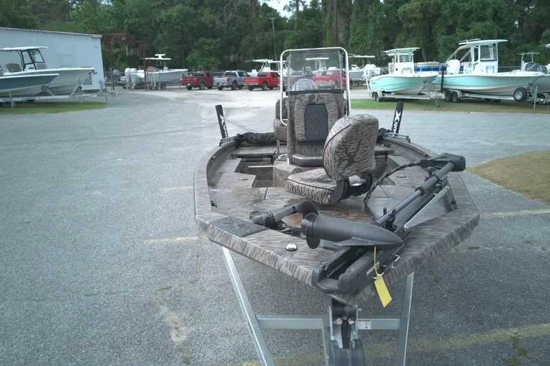 Slide: The Image of 2024 Xpress H20B Bay boat in a parking lot with other boats. - 16