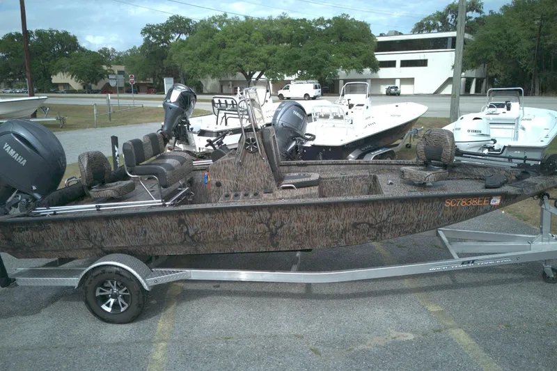 Slide: The Image of 2024 Xpress H20B Bay boat with Yamaha engine on a trailer, parked outdoors. - 3