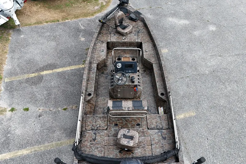 Slide: The Image of 2024 Xpress H20B Bay boat with camouflage design, aerial view of deck and controls. - 5