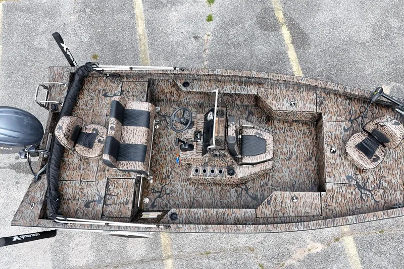Slide: The Image of 2024 Xpress H20B Bay boat with camouflage design, aerial view showcasing seating and steering console. - 6