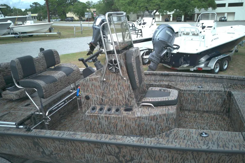 Slide: The Image of 2024 Xpress H20B Bay boat with camouflage interior and Yamaha outboard motor. - 9
